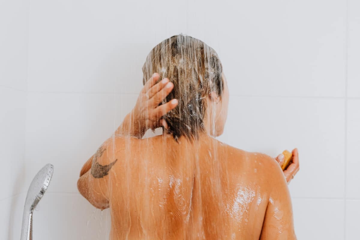 Persona en la ducha tomando un baño.